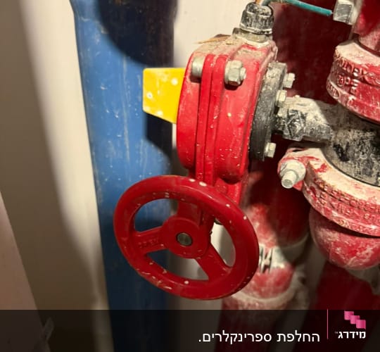 שסתום אדום ומד לחץ בצנרת כיבוי אש